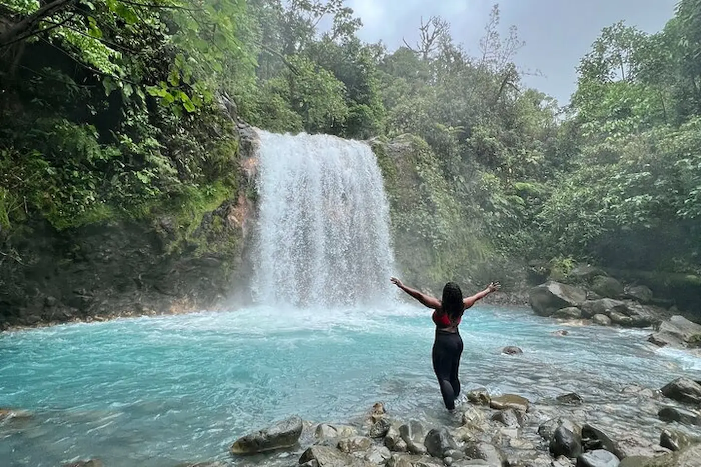 Hikers at a waterfall in a green canyon, northern Costa Rica