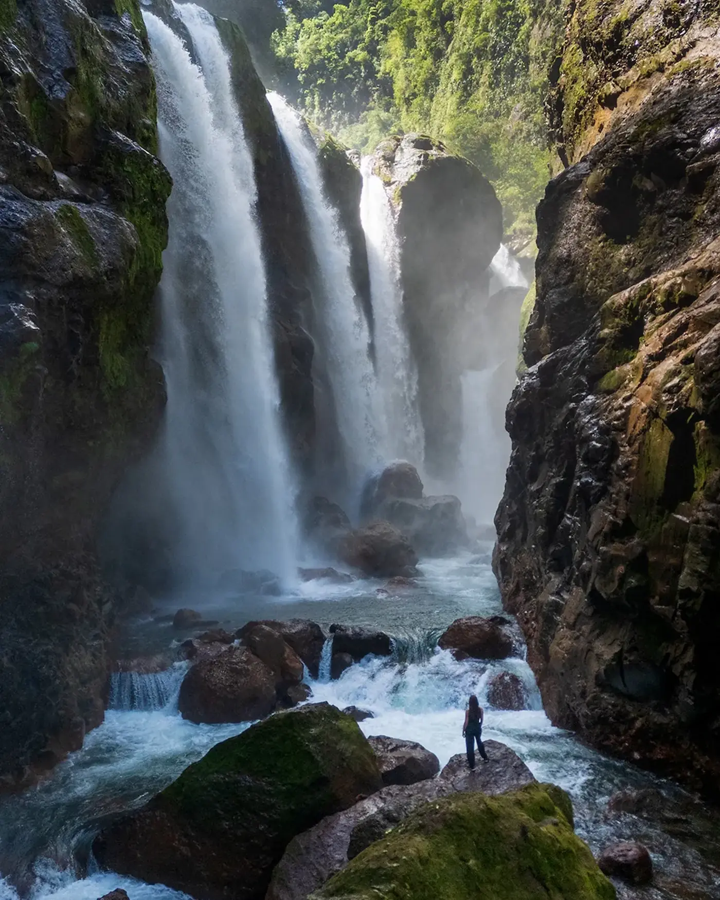 Hiker at the Quebrada Gata waterfall in a volcanic canyon, Costa Rica